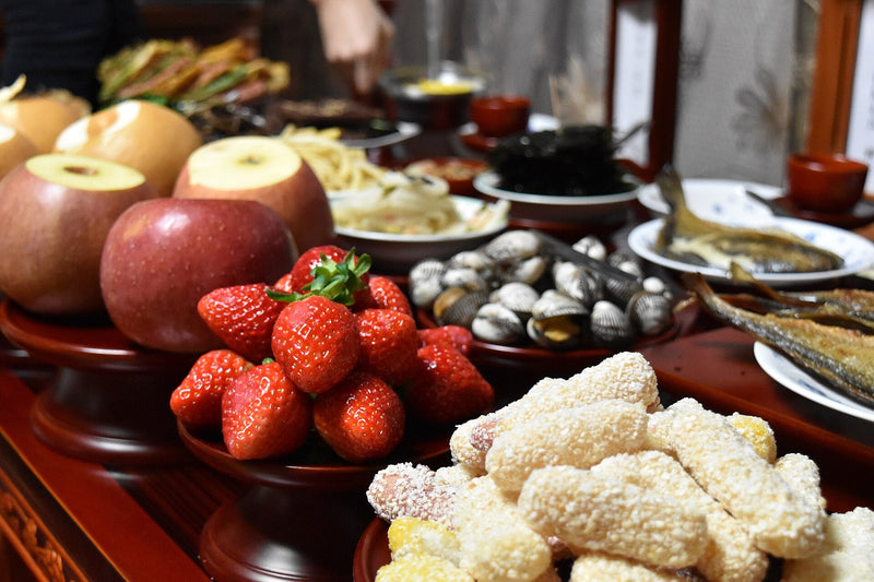 Seollal charye table laid with apples, strawberries, fish and rice cakes