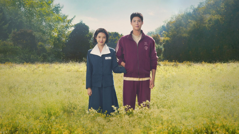 『おつかれさま』のキービジュアル、黄色い花畑に並んで立つIUとパク・ボゴム