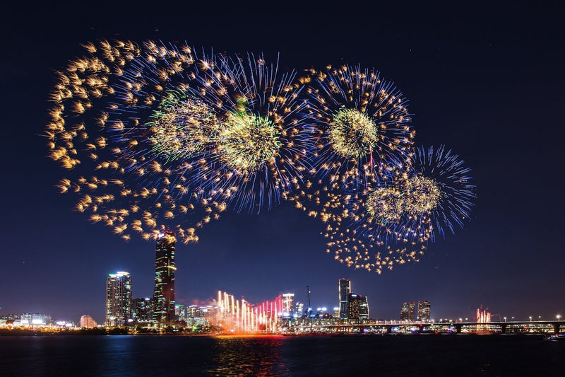 夜の汝矣島のスカイラインと漢江の上に広がる金色の花火