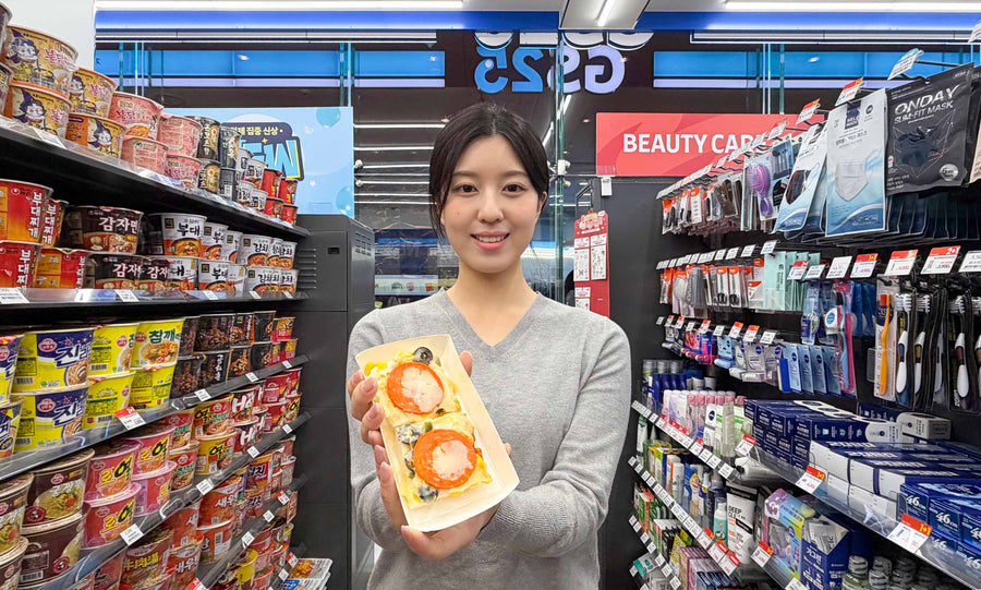 GS25 Sulbing Pizza Seolgi held up in a bright GS25 aisle, two rice-cake squares topped with pepperoni and cheese