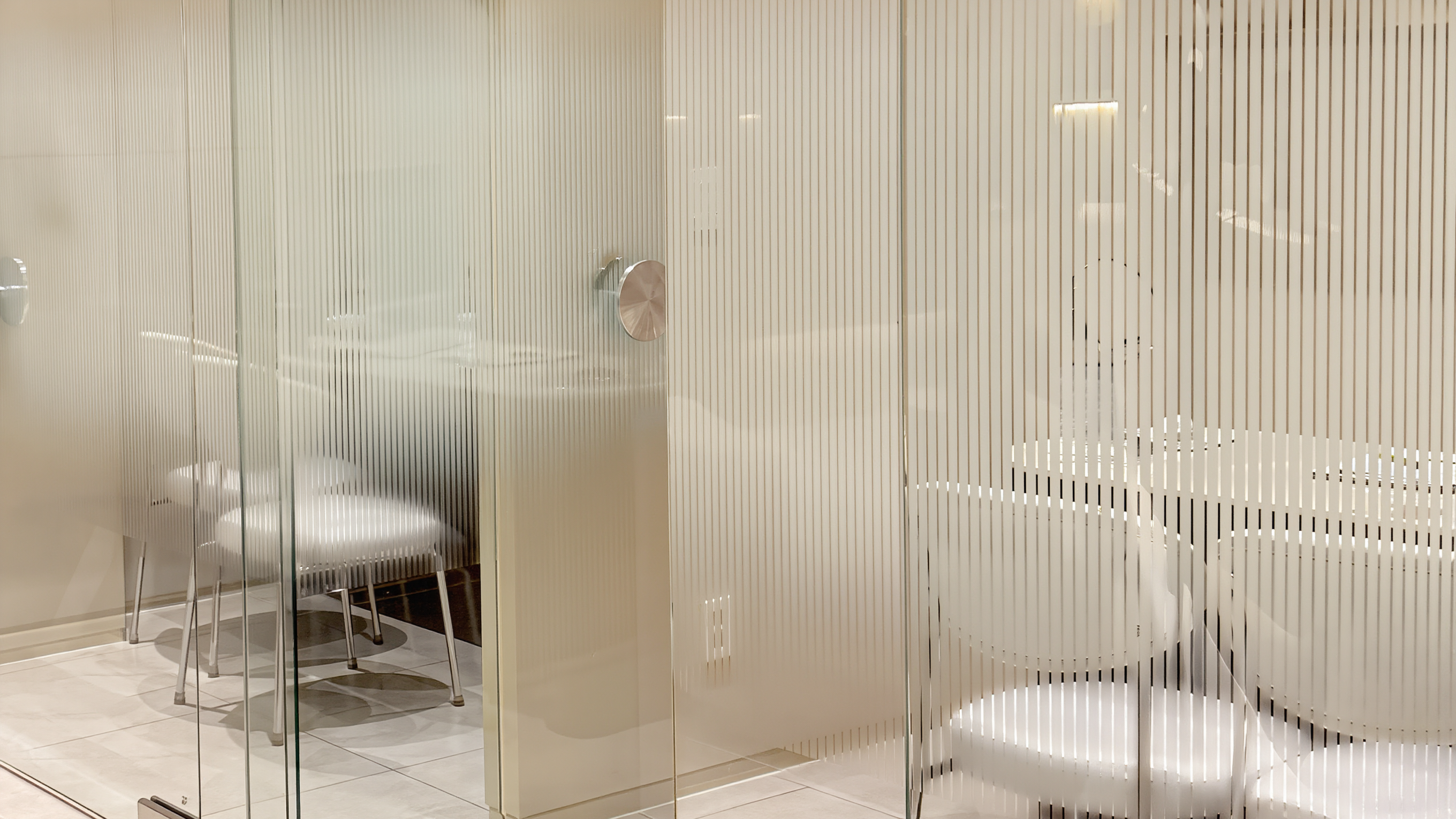 Dermatology clinic in Seoul: bright glass consultation rooms with white chairs in soft morning light