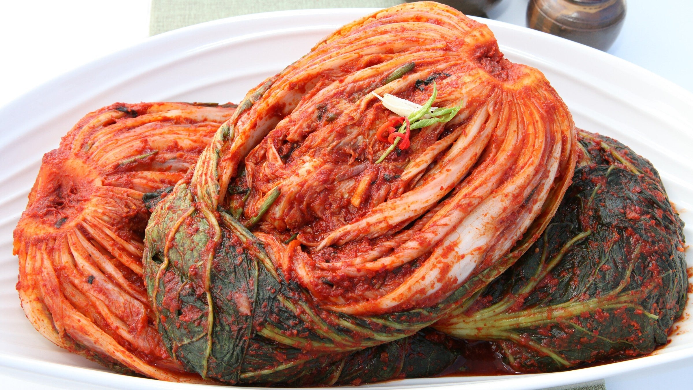 白色盤子上整顆醃好、紅通通的白菜泡菜（Photo: gwangju kimchi / CC BY-SA 2.0）