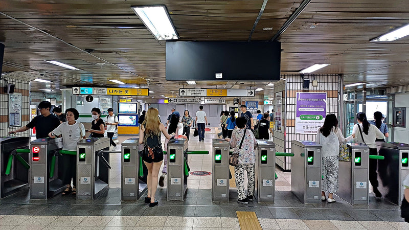 Seoul subway fare gates at Guro Digital Complex Station, riders tapping transit cards on a busy day