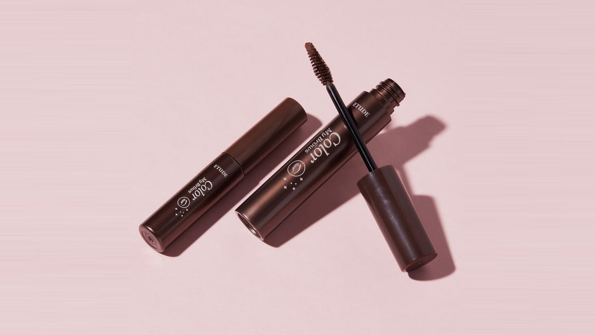 Etude Color My Brows brow mascara tubes on a pink backdrop, a no-bleach way to soften Korean-style brows