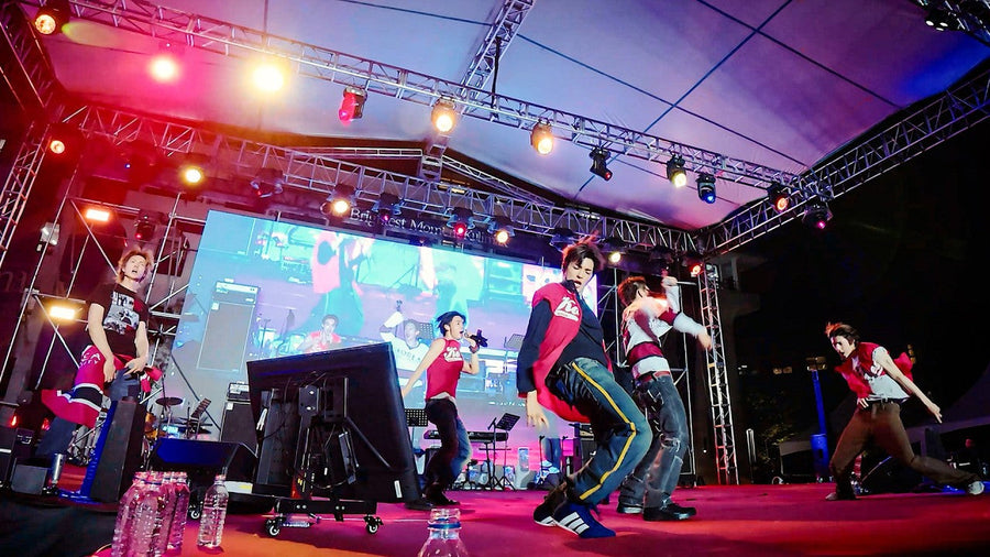 CORTIS performing YOUNGCREATORCREW live on an outdoor stage at Korea University under bright rig lights