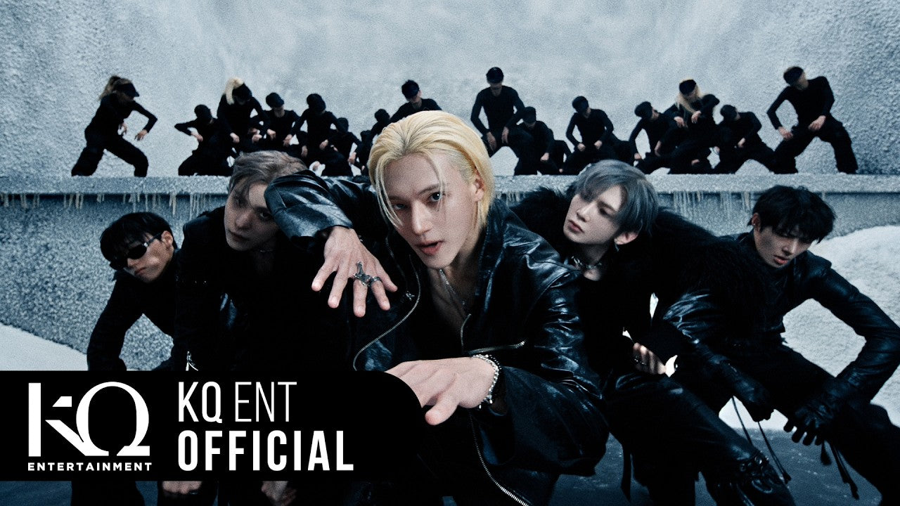 ATEEZ members in black leather outfits posing in front of a crew of dancers in the Drip music video