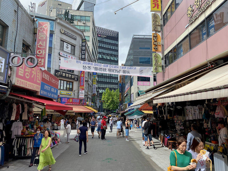 Black Friday in Korea shopping scene on a busy Namdaemun Market street in Seoul on a bright summer day