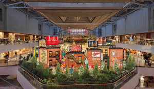 Rendering of The Hyundai Seoul's 2026 Christmas village: red-brick New York buildings, neon signs and pines in Sounds Forest