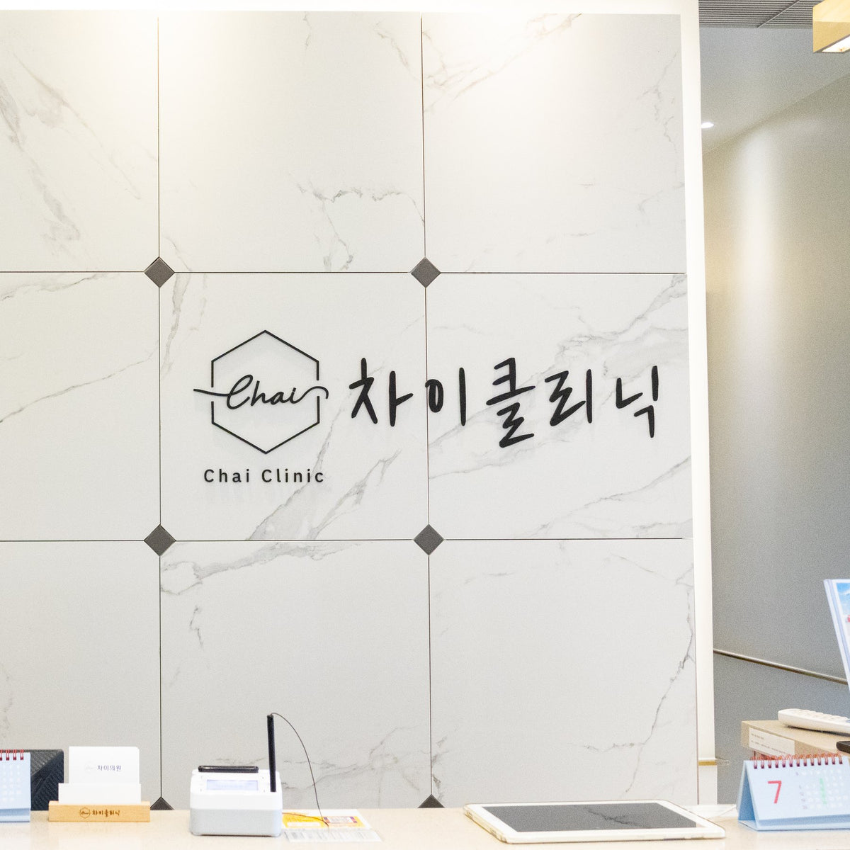 Reception desk and logo wall at CHAI Clinic