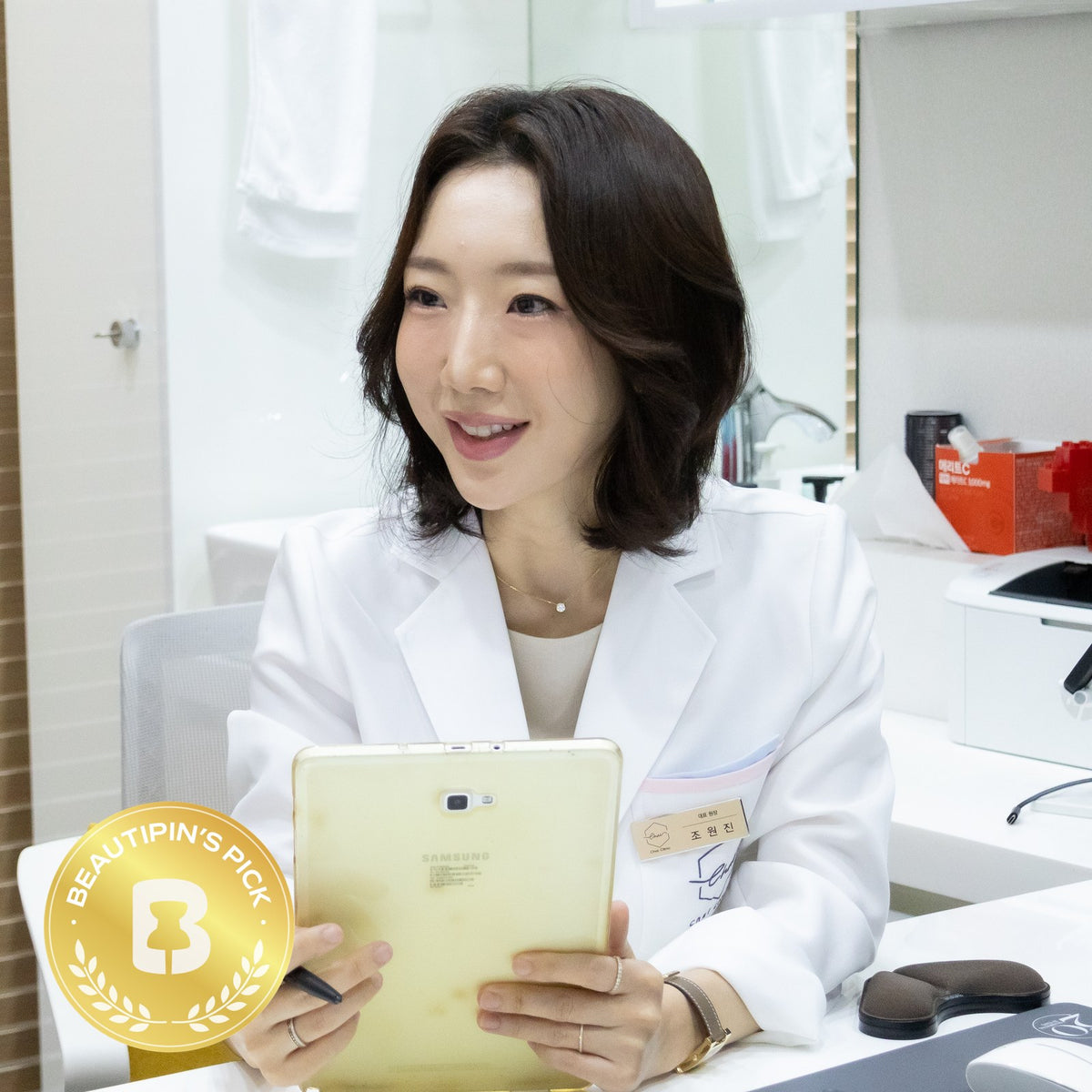 Dr. Wonjin Cho, Chief Director of CHAI Clinic, with the BeautiPin's Pick badge